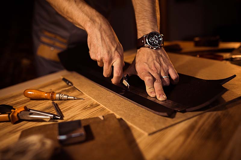 Amish craftsman working with leather